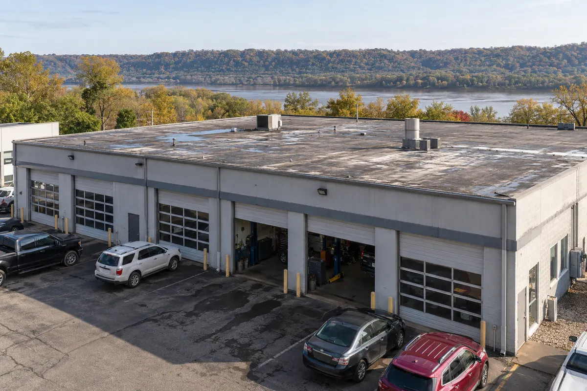 Single-story commercial building with service bays and a flat roof near the river